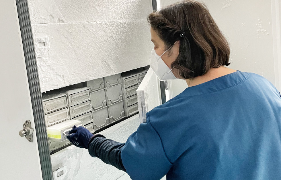 Researcher in front of high-performance freezer 