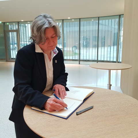 The rector signs the guest book.
