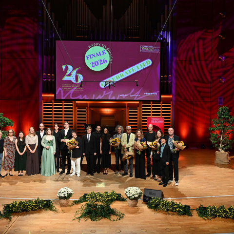 Gruppenfoto der Preisträgerinnen und Preisträger mit der Jury auf der Bühne.