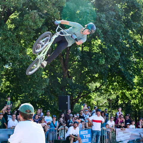 BMX-Fahrer beim Sprung mit Publikum im Hintergrund