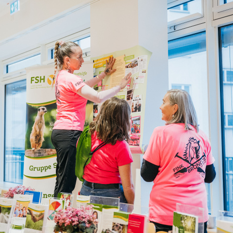 Menschen bauen einen Info-Stand auf