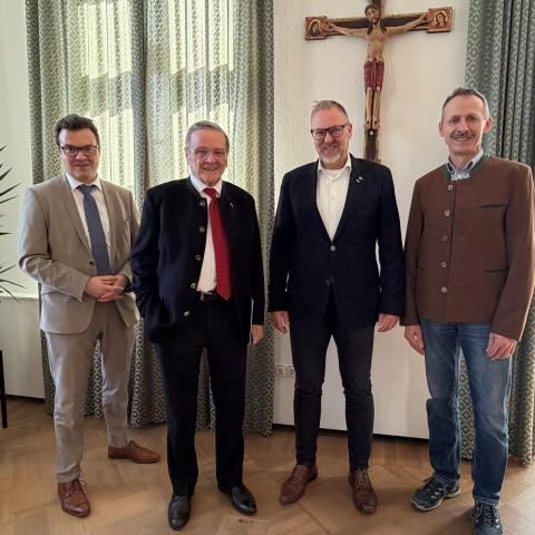 Vier Männer in Anzügen im Landratsamt Traunstein. 