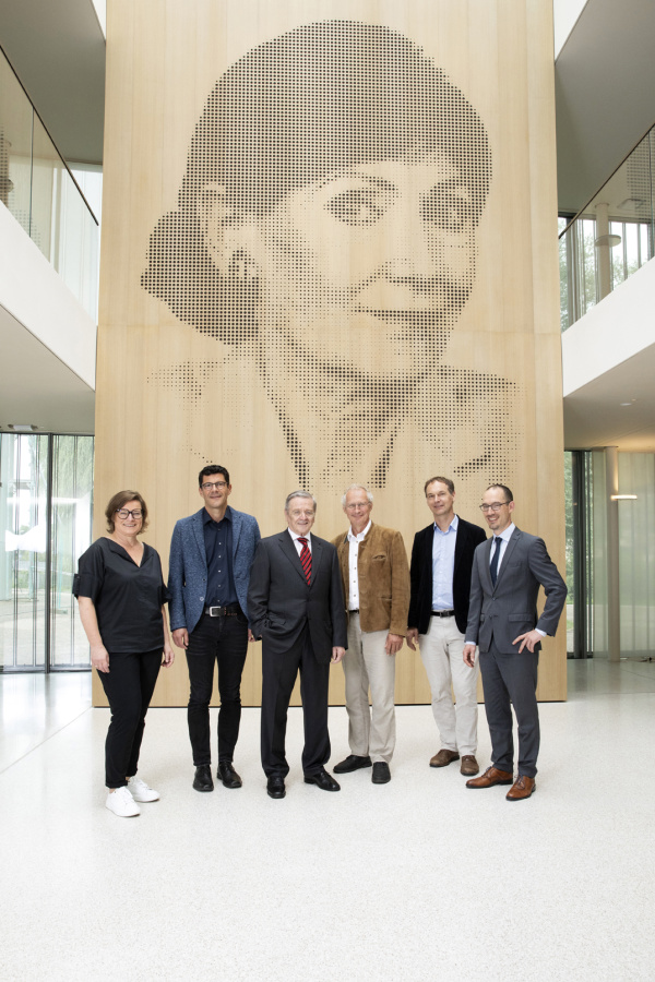 Gruppenbild unter dem Portrait der Stifterin